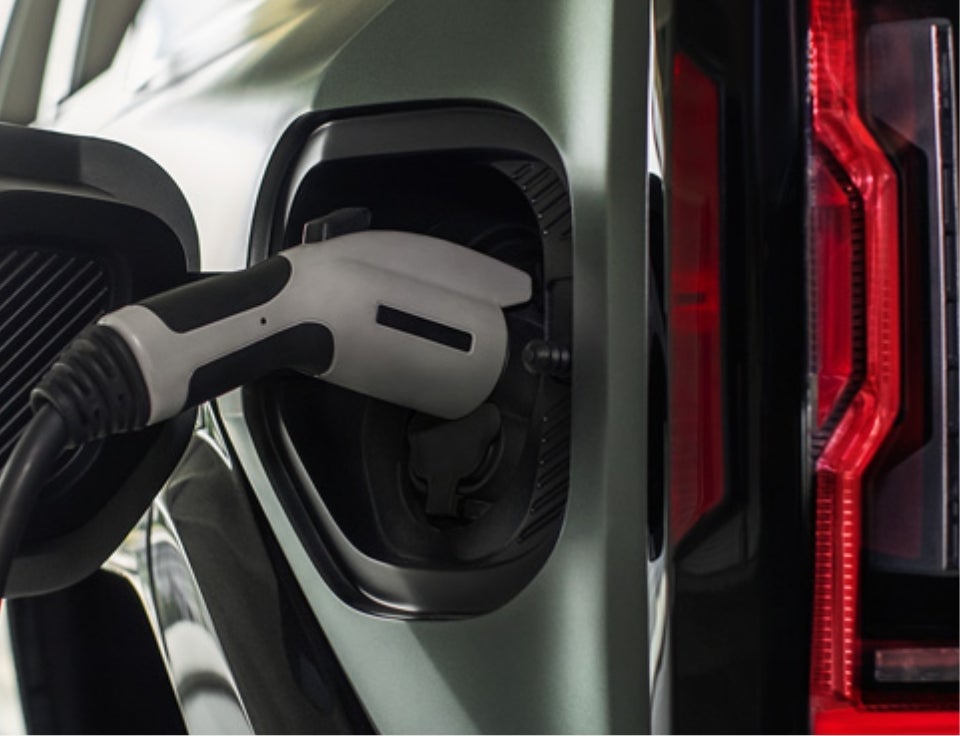 Close up of charging port with charger plugged in on a GMC Hummer EV SUV - Weis GMC Inc in DECORAH IA